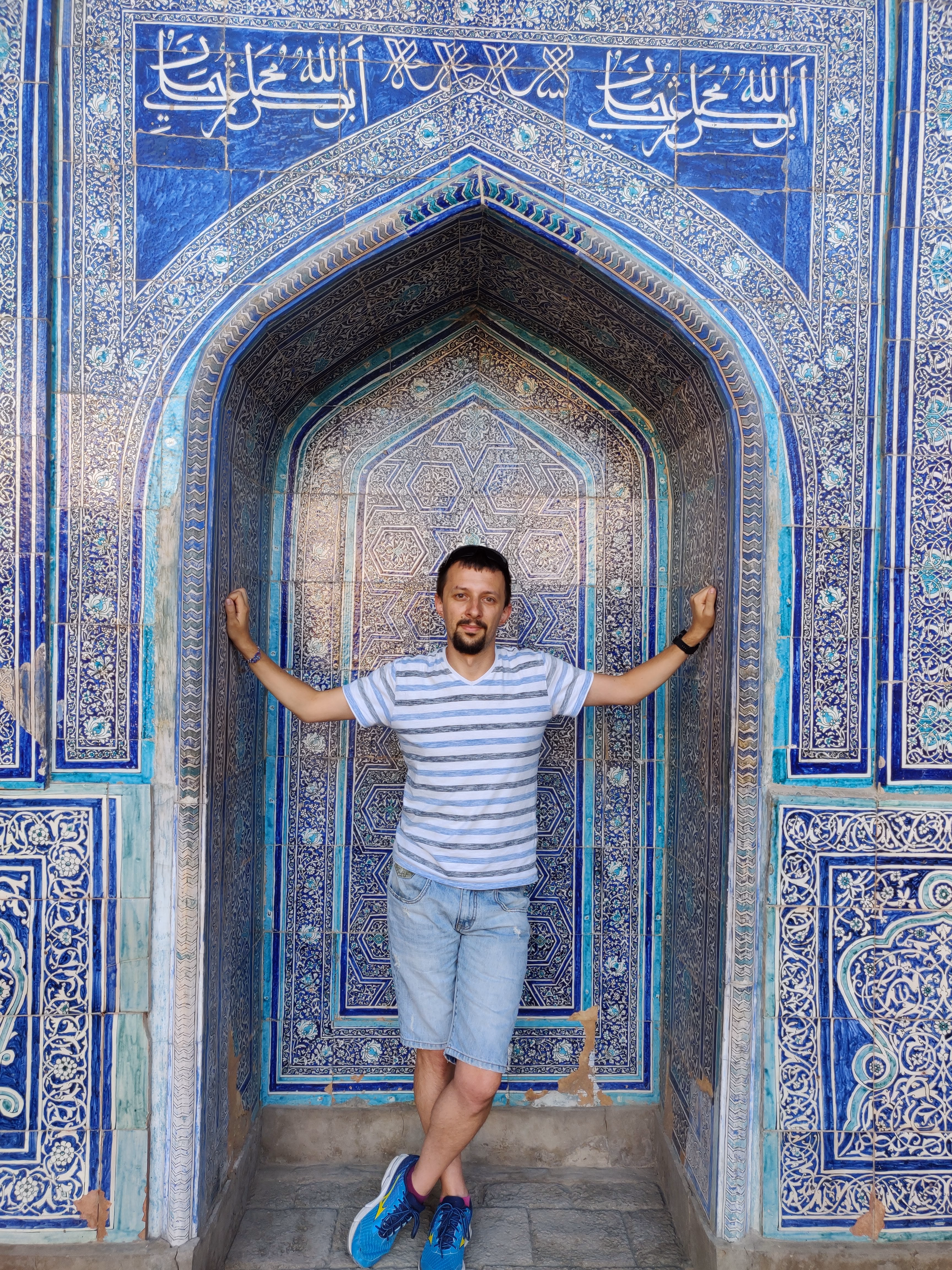Alex standing in a blue-tiled alcove in Uzbekistan