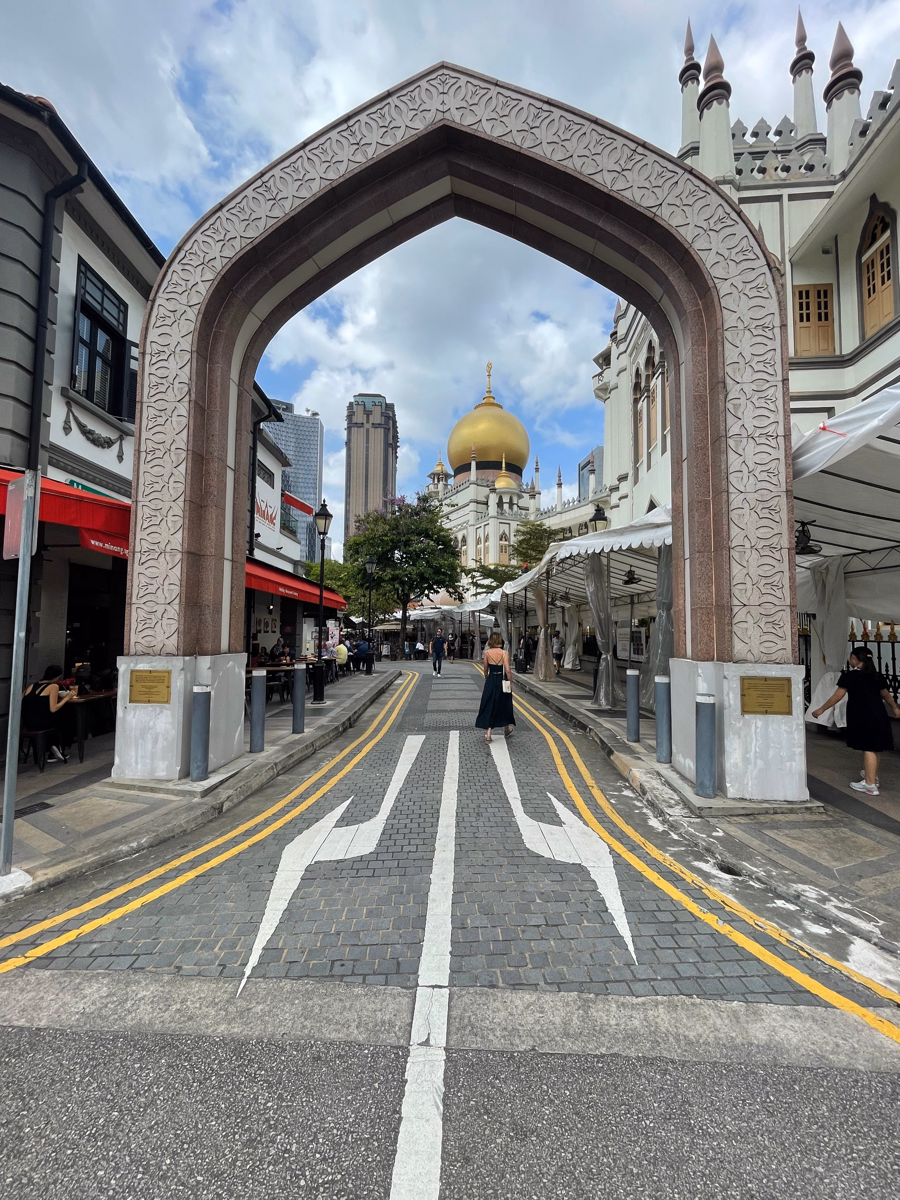 An arched gate framing the golden dome of the Sultan Mosque in Kampong Glam.