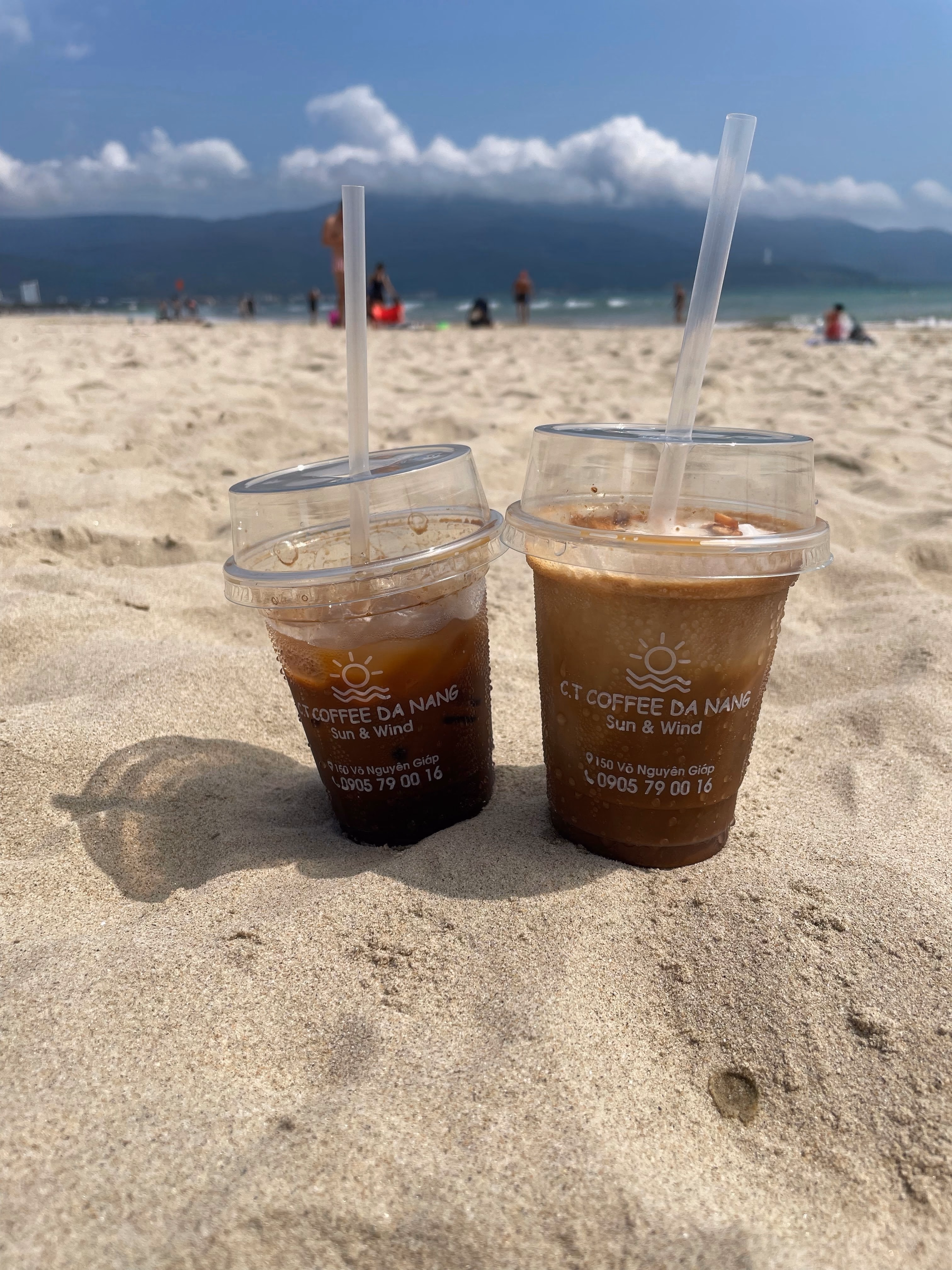 Two iced coffees from a beach café in the sand.