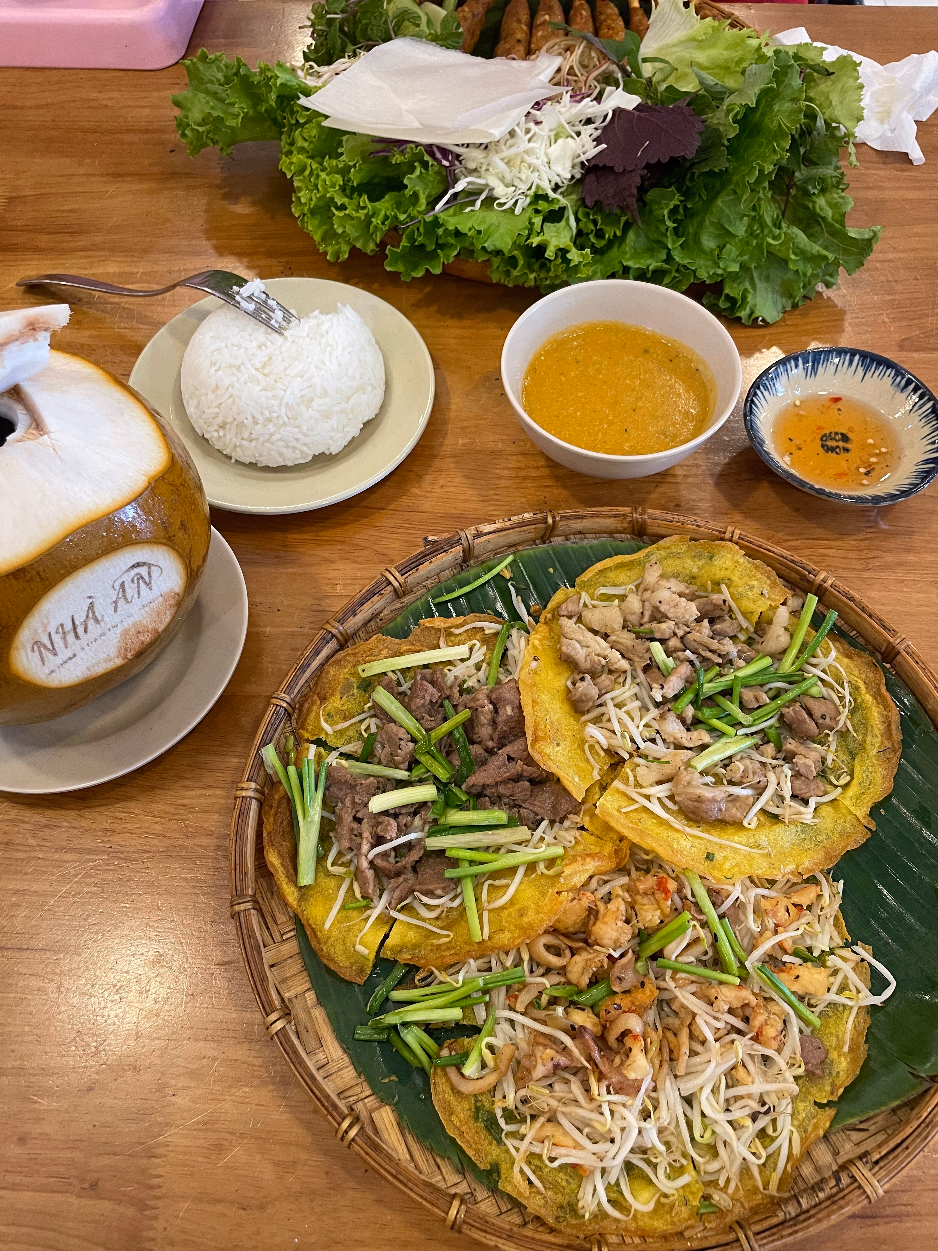 Bánh xèo crepes with fresh herbs and dipping sauces.