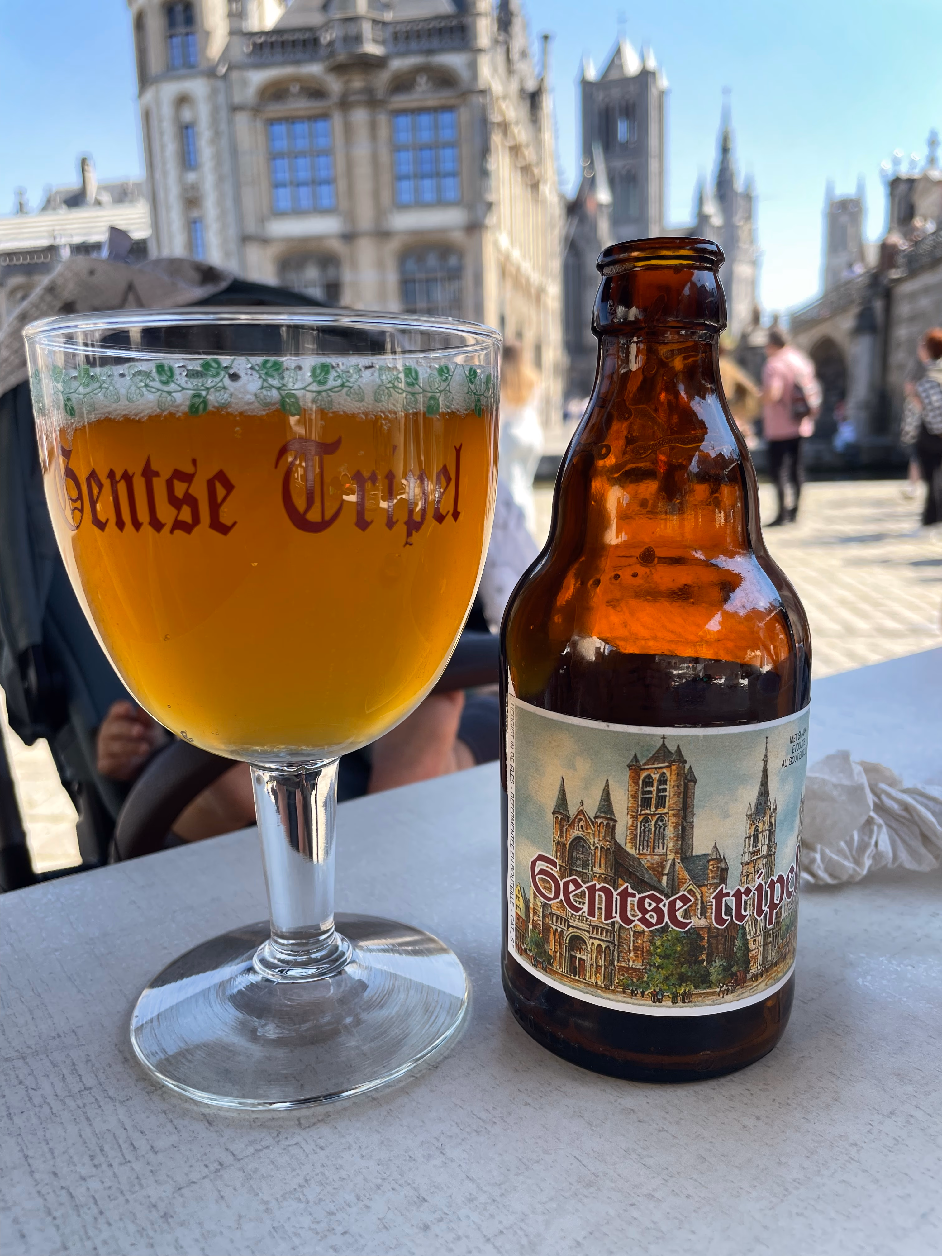 A pint of Belgian beer sitting on an outdoor terrace in Ghent.