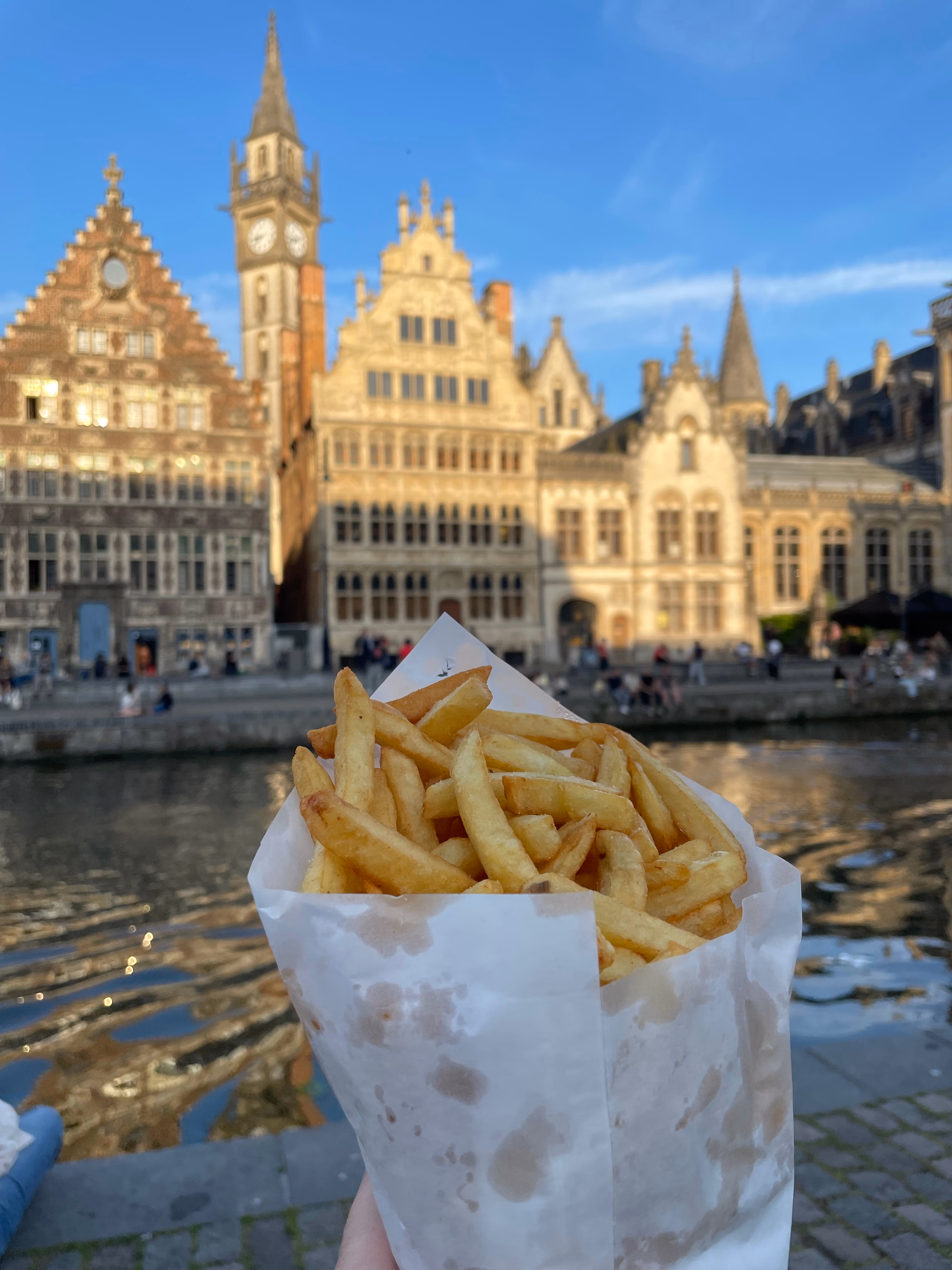 Paper cone of frites (fries) with mayonnaise on a Ghent street.