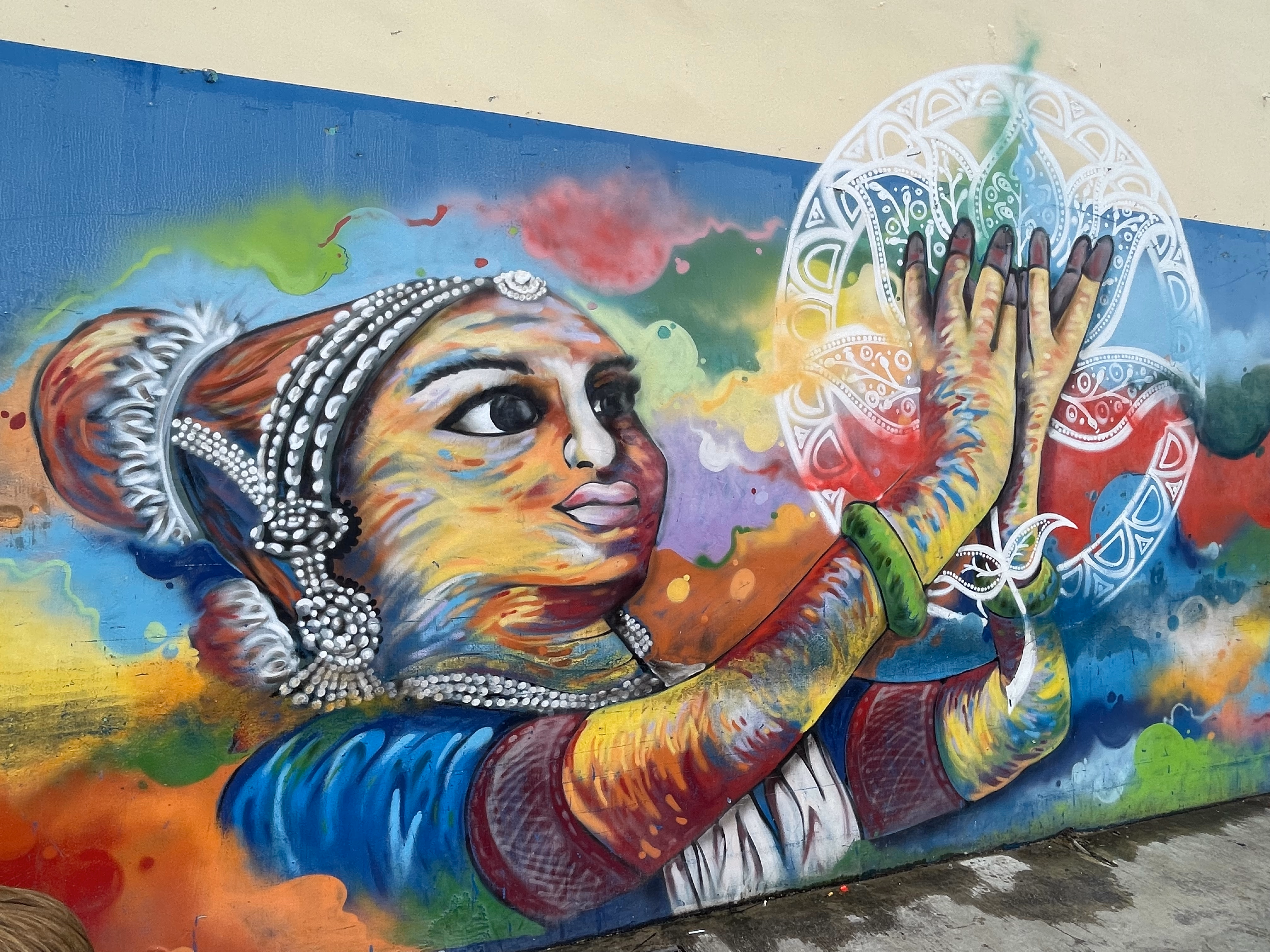 A mural of a dancer in traditional jewellery painted on a wall in Little India.