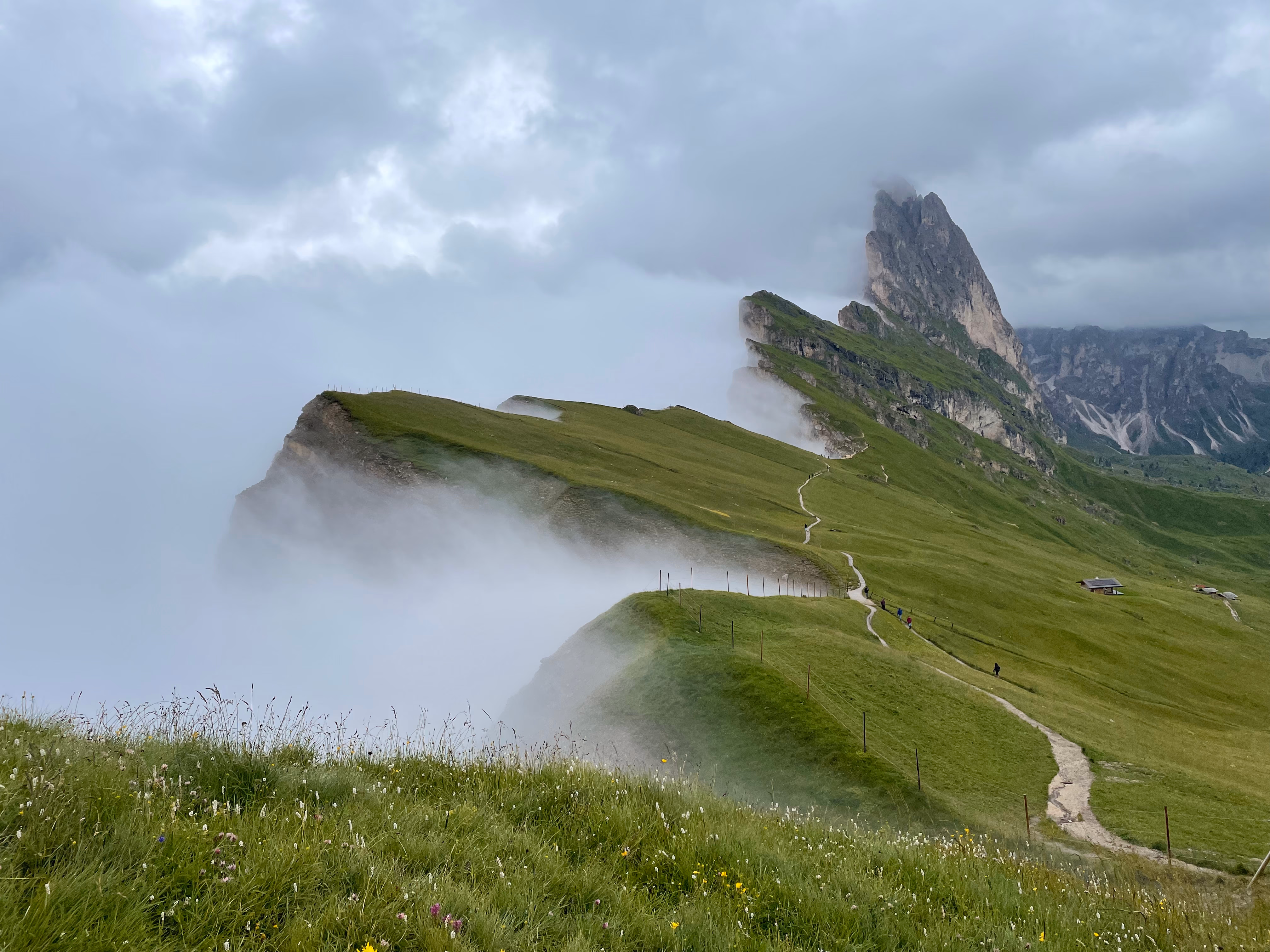 The jagged peaks of Seceda with heavy clouds in the valley below