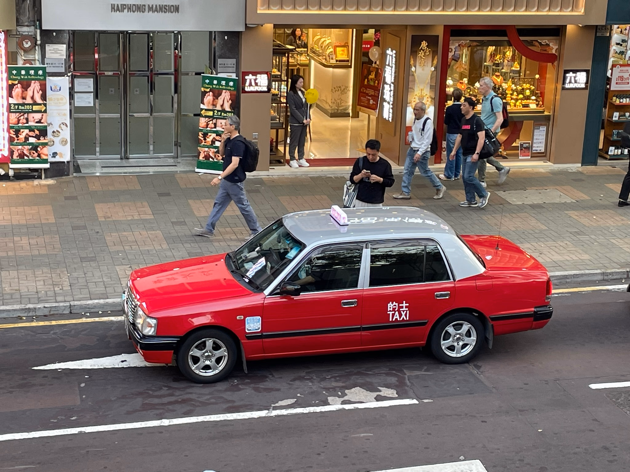 A classic red taxi in Kowloon.