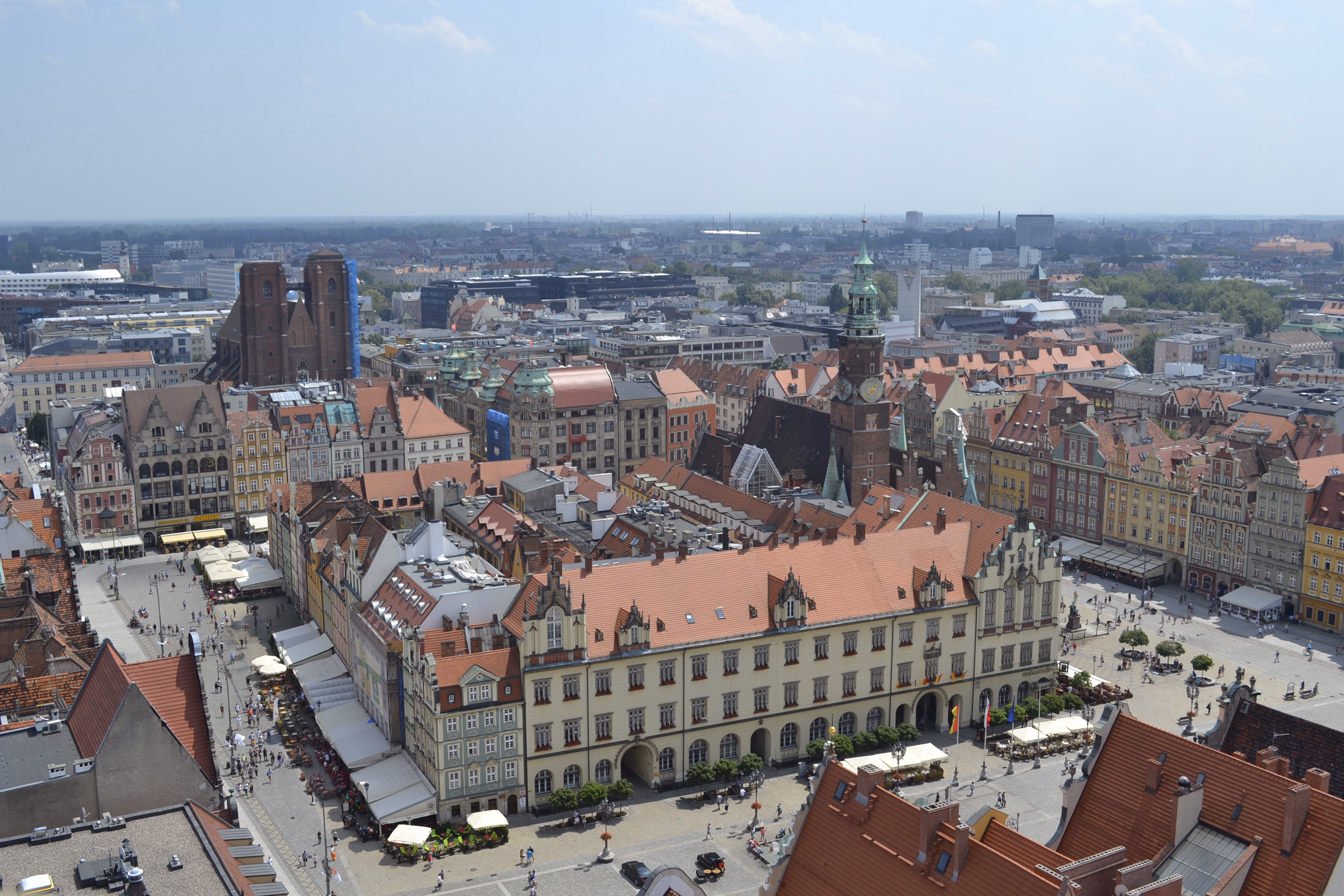 Wrocław from above — the Rynek's red roofs, the Old Town Hall clock tower and the twin spires of St Mary Magdalene in the distance.